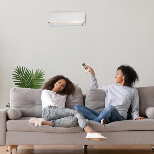 family relaxing on couch with air con unit on wall